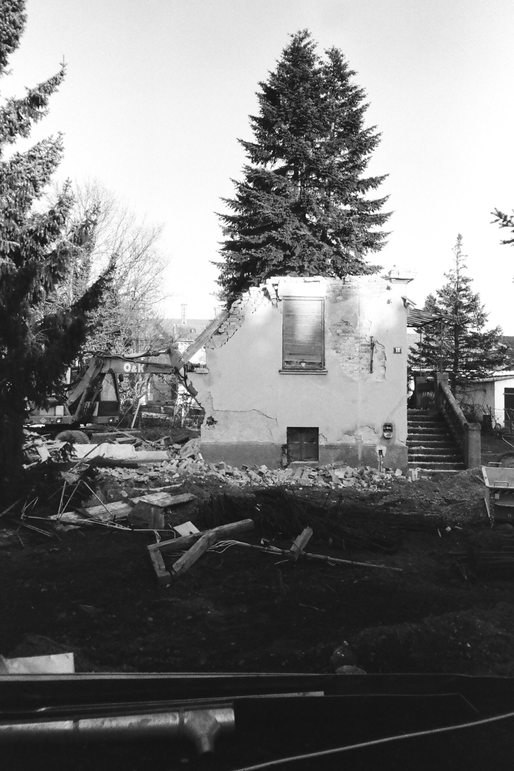Black and white photograph of an old house being demolished with only one wall standing in Varaždin, Croatia